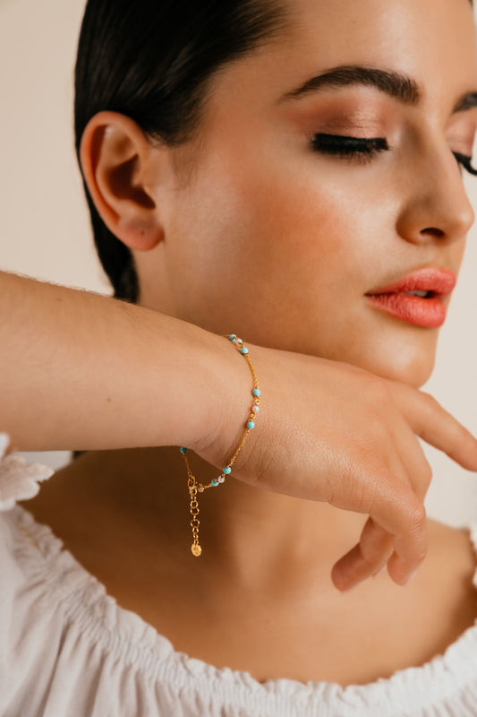 Model wearing Bahr turquoise and pearl 18k gold bracelet by Hafeez Jewellery London