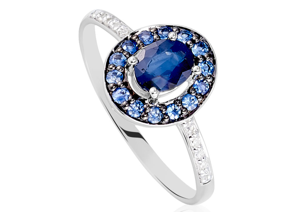 Platinum ring with blue sapphires and diamond accents on a white background