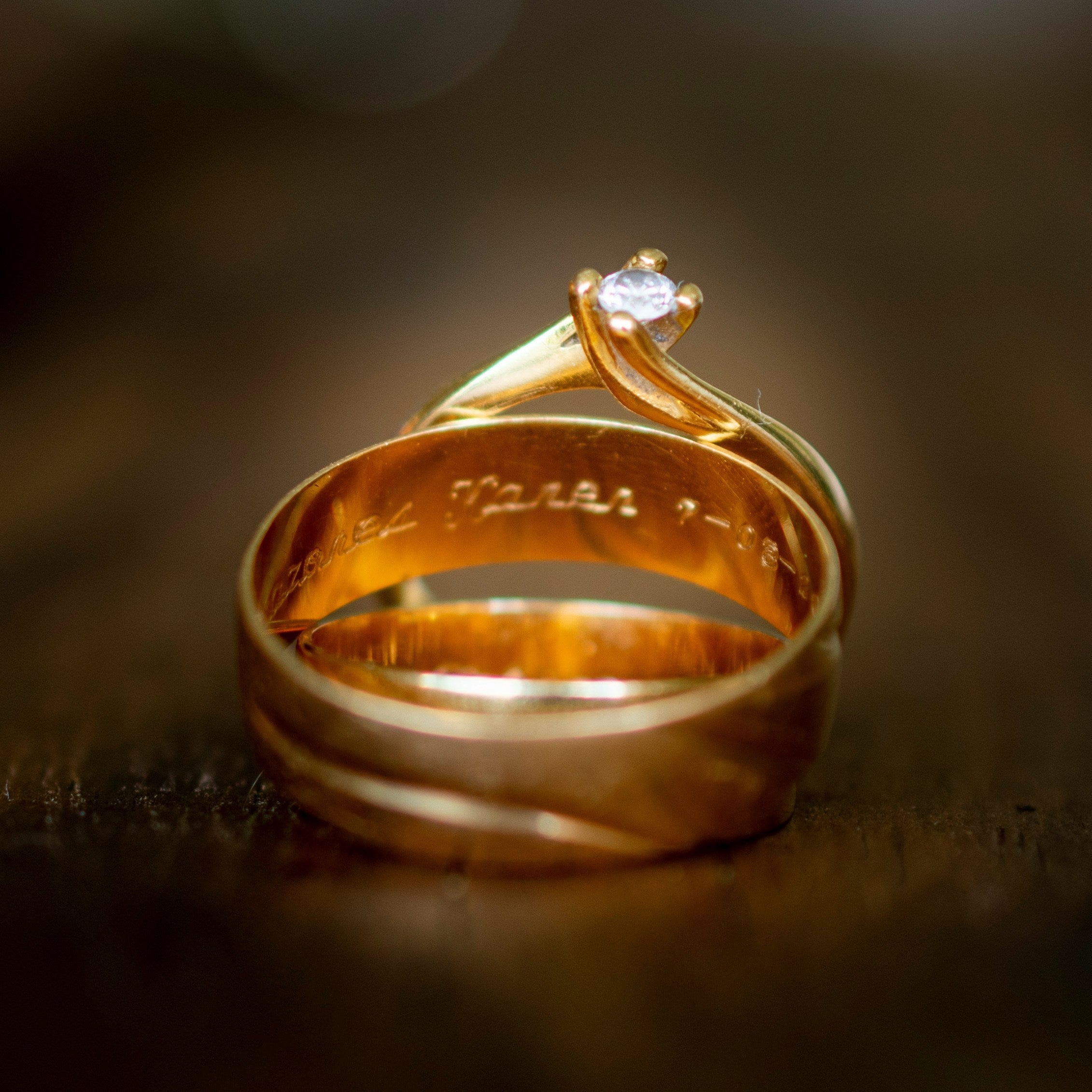Engraved gold ring with a diamond on a dark background