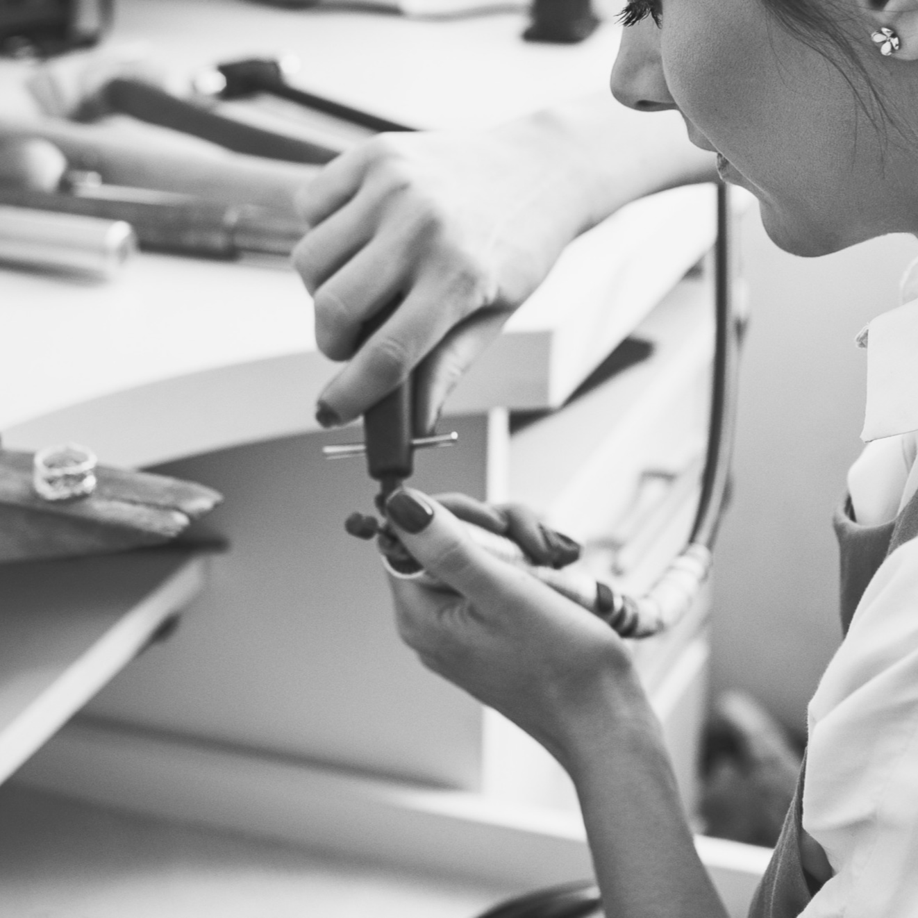 Woman working on jewelry with a focus on hands and tools