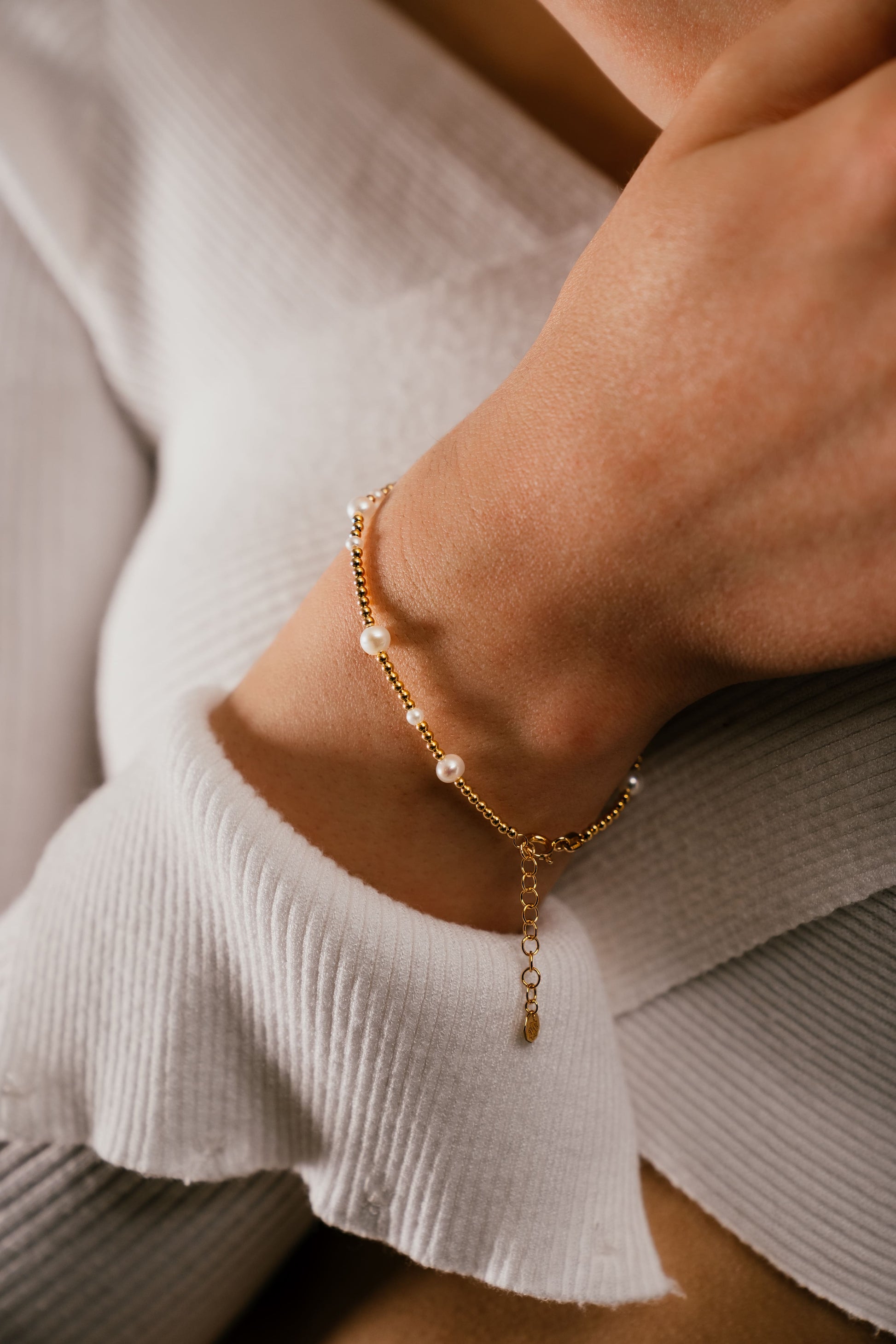 Model wearing Lulua 18k gold pearl beaded bracelet by Hafeez Jewellery London
