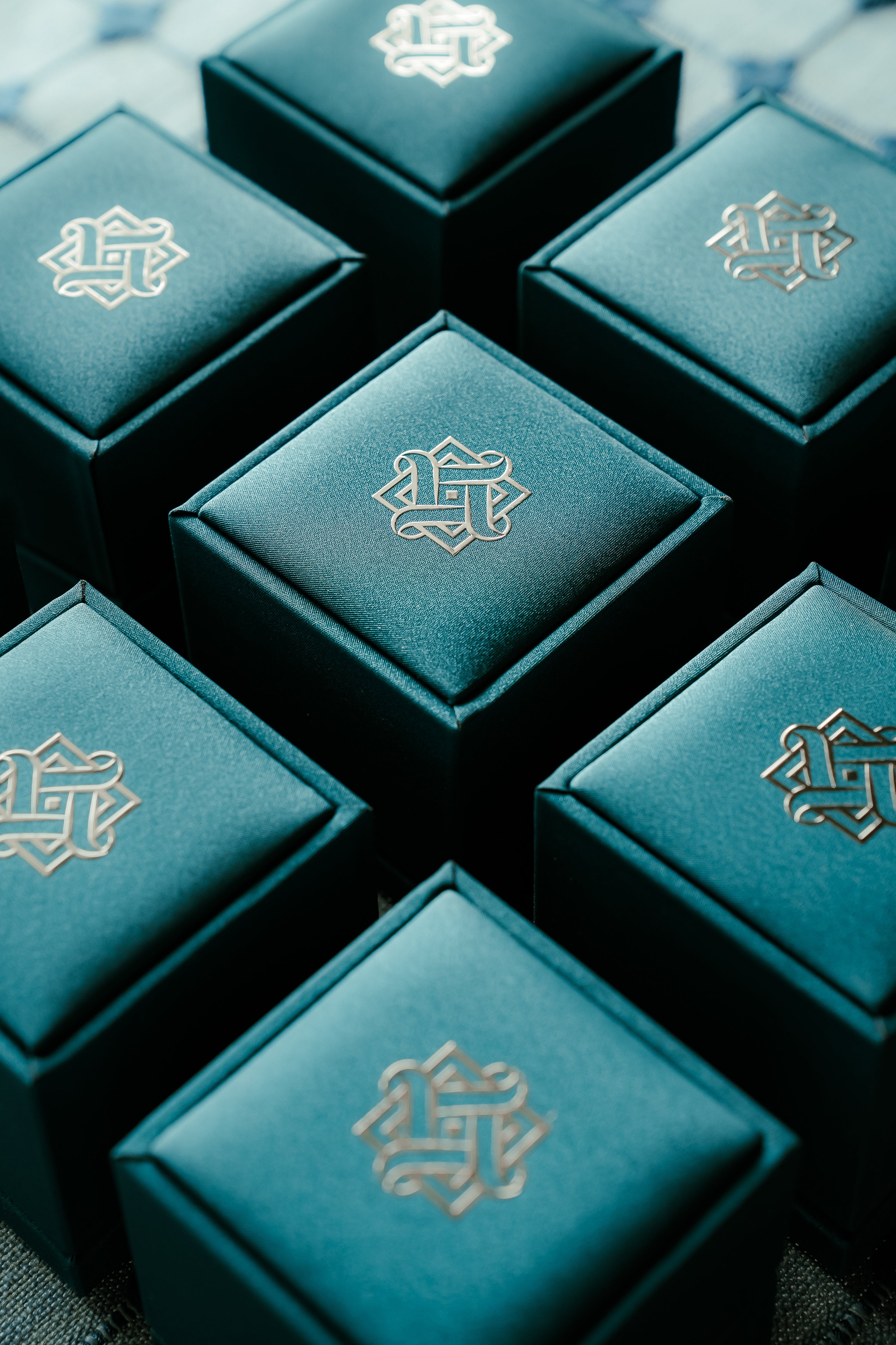 Hafeez teal jewelry boxes with a logo on a textured surface