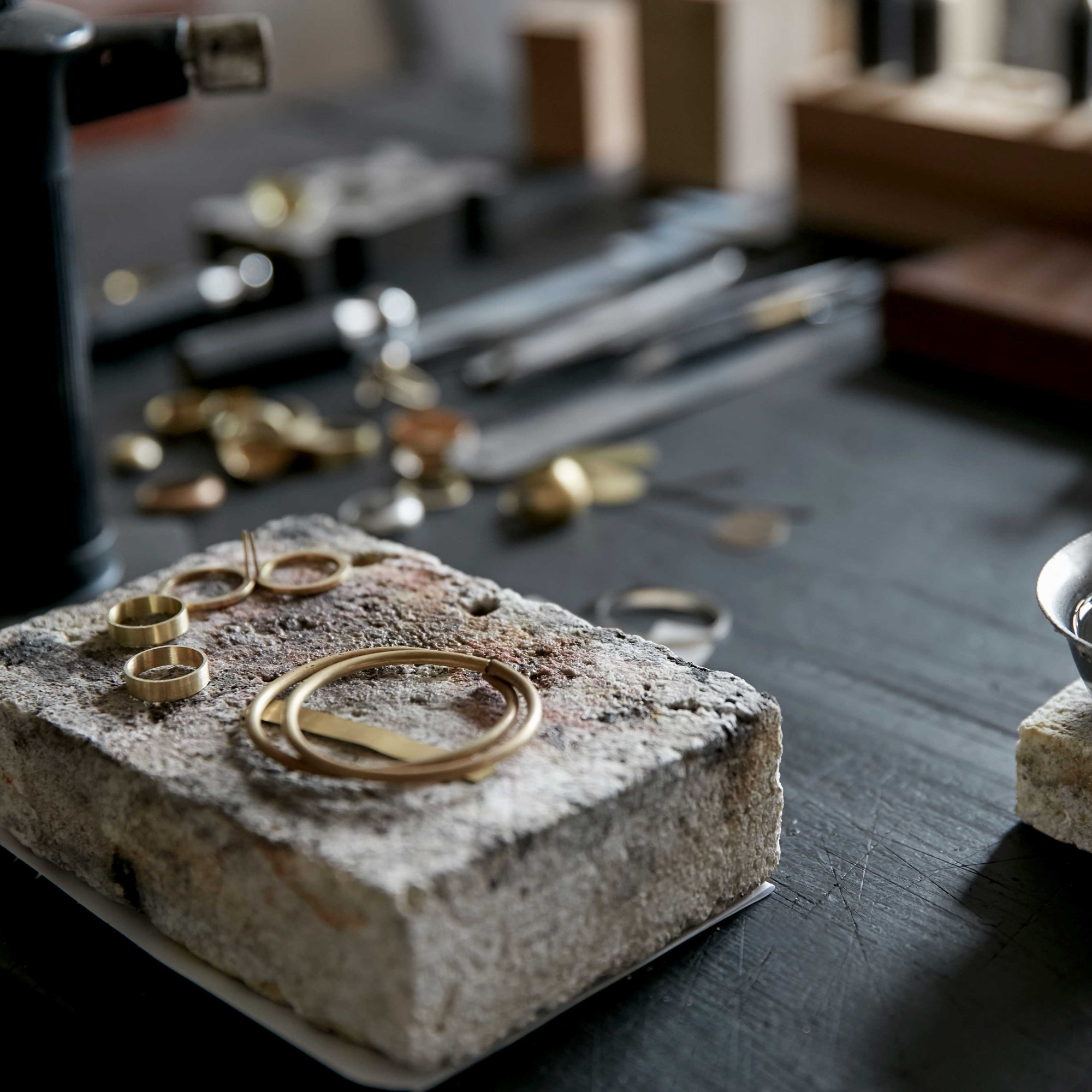 Gold rings on a stone block with a workshop background